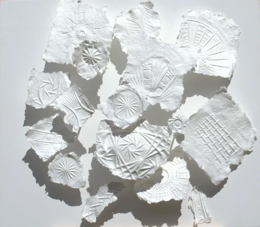 Dreidimensionales Wandrelief „Transformation des Glases“ mit geprägten Fragmenten aus weißem, geschöpftem Papier auf Holz